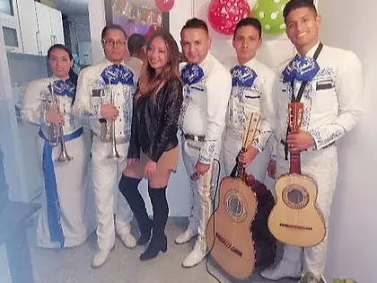 Grupo de mariachis en Bogotá junto a una clienta tras la serenata